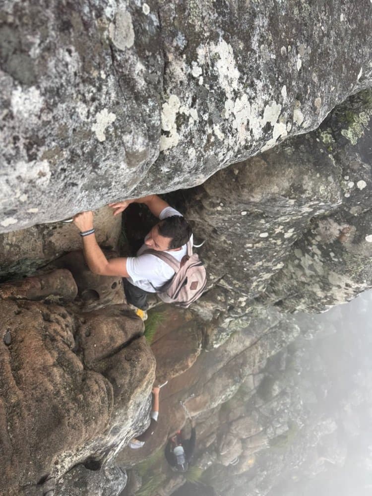 Scrambling up a rock face on a misty mountain