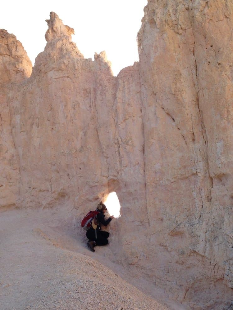 Climbing through a sandstone rock arch